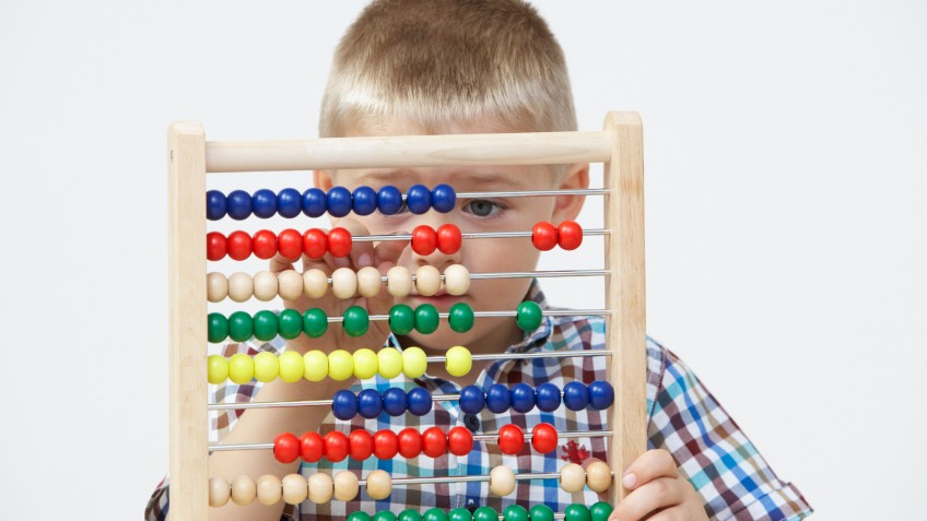 Studio Shot Of Boy Playing With Abacus