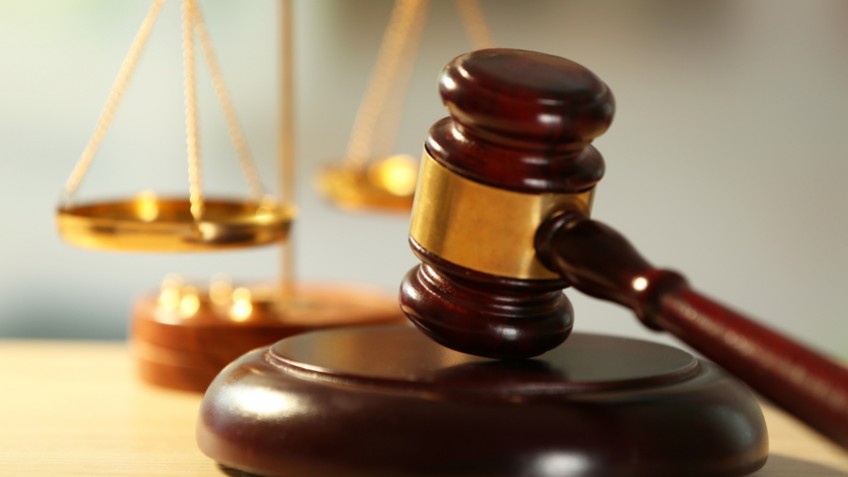 Wooden judges gavel on wooden table, close up