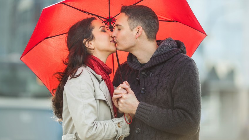 Couple in love under red umbrella.