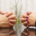 Man and woman sits at a desk with hands clasped. marital problem