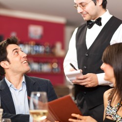 Waiter serving a couple at restaurant