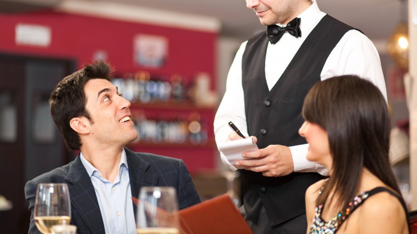 Waiter serving a couple at restaurant