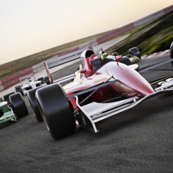 Red race car close up front view on a track leading the pack