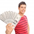 Happy young man holding a pile of cash