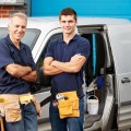 Workers In Family Business Standing Next To Van