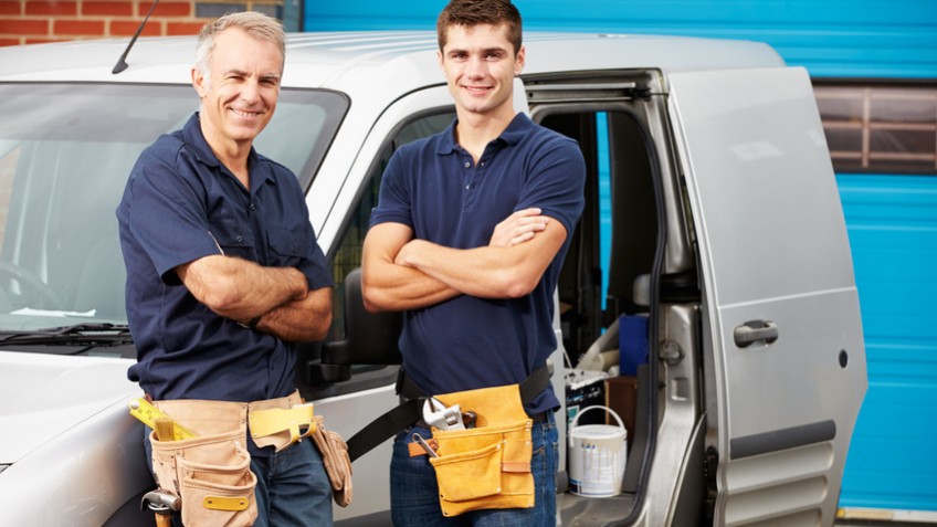 Workers In Family Business Standing Next To Van