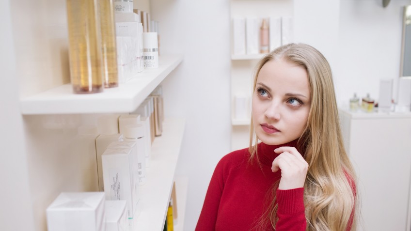 Young woman choosing cosmetics in a drugstore