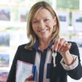 Estate Agent In Office Holding Keys To Property