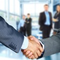 Business associates shaking hands in office