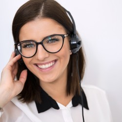 Smiling businesswoman with headset over gray background