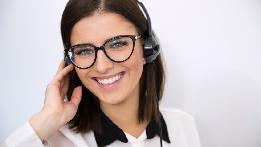 Smiling businesswoman with headset over gray background