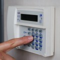 Finger pressing keys on alarm keypad