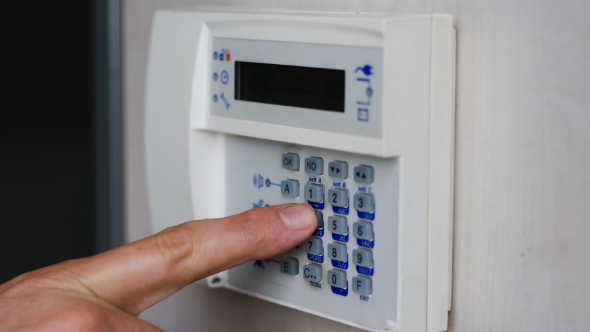 Finger pressing keys on alarm keypad