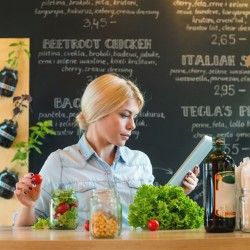 Small business owner reading the recipe on a digital tablet