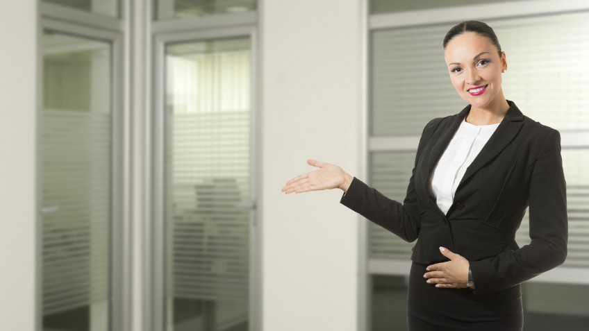 Successful young business woman in front of her office.