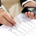 Female hands reviewing accounting document.