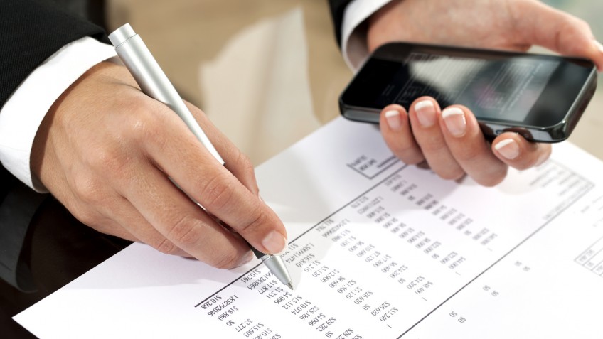 Female hands reviewing accounting document.