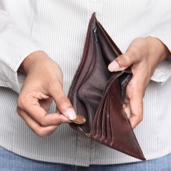 Business person taking a penny from a wallet