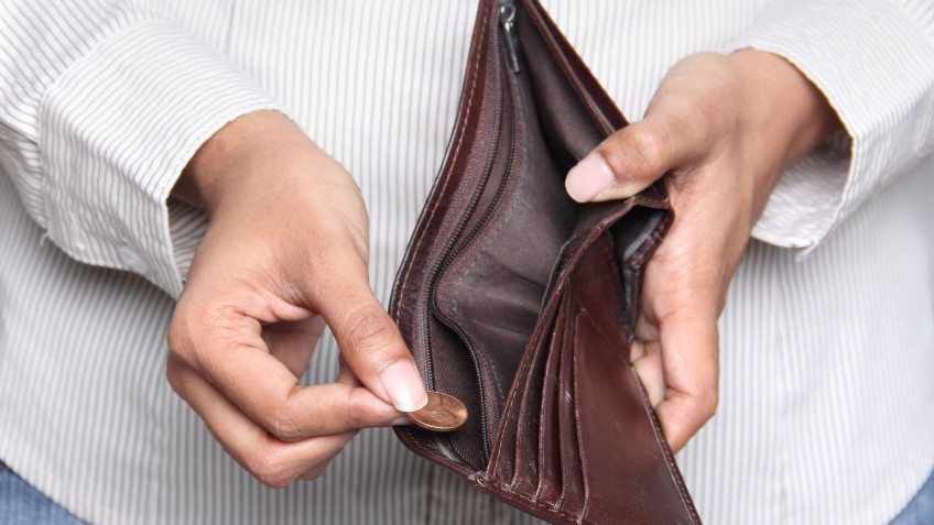 Business person taking a penny from a wallet