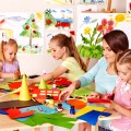 Children  cutting out scissors paper in preschool.