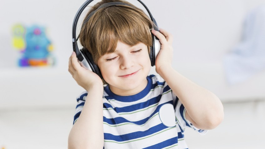 Cute boy wearing headphones and enjoying music