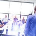 Business man making a presentation at office. Business executive delivering a presentation to his colleagues during meeting or in-house business training, explaining business plans to his employees.