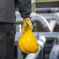 worker with helmet in front of production hall