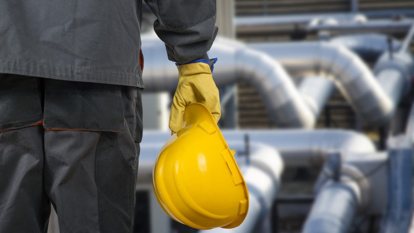 worker with helmet in front of production hall