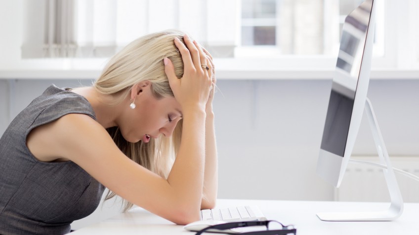 Overworked and tired young woman in front of computer