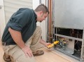 HVAC technician using a meter to check heat pump amperage