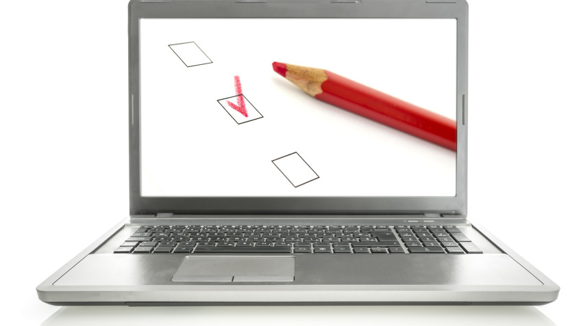 Laptop with red pencil and check boxes on screen. Online survey concept.