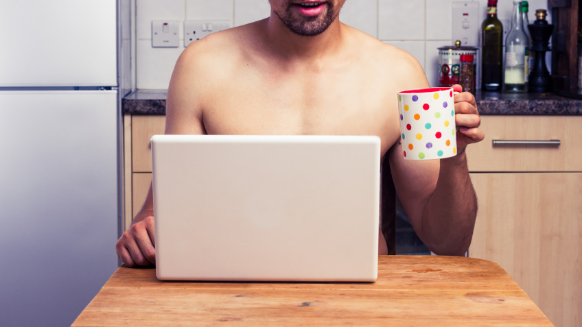 Naked man at home with laptop and coffee