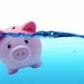 Piggy bank drowning in debt - savings to risk