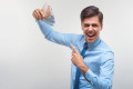 Businessman celebrating money income against white background