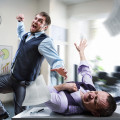 Two agressive businessmen fighting in the office