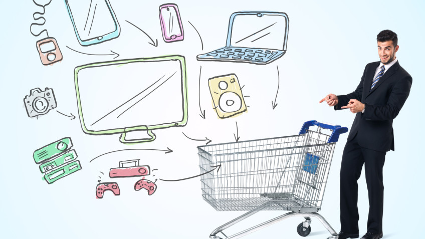 Businessman pushing a shopping cart drawn media devices coming out of it