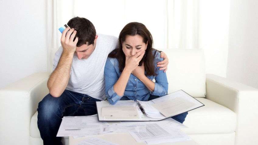young couple worried at home in stress accounting bank documents