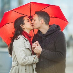 Couple in love under red umbrella.
