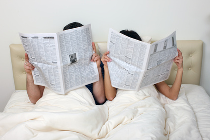 Couple reading newspapers