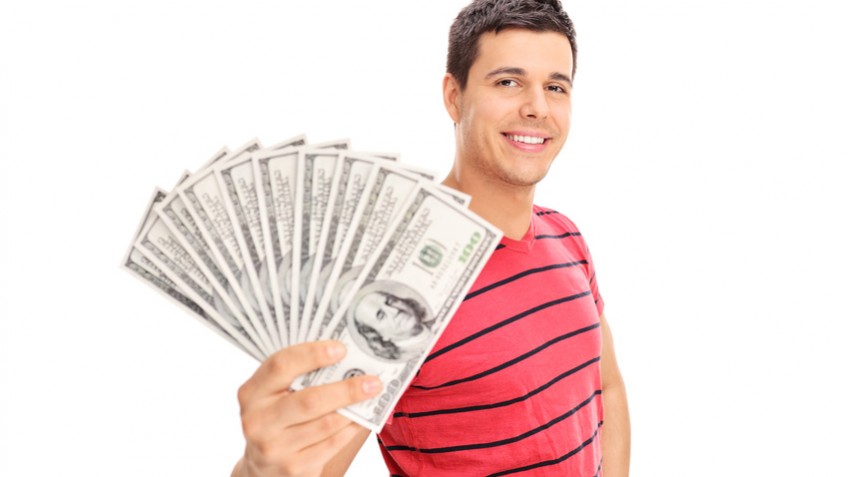 Happy young man holding a pile of cash