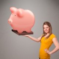 Young girl holding a huge savings piggy bank