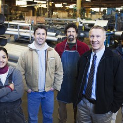 Foreman and workers standing in factory