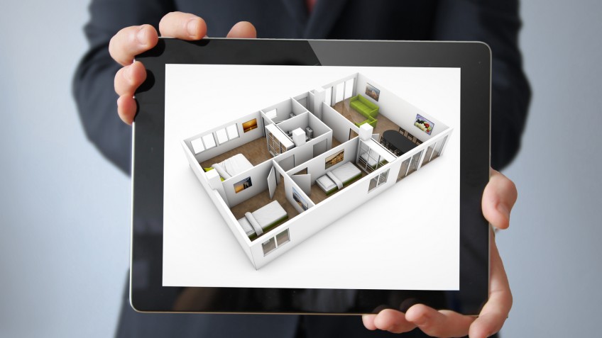 interior design concept: businessman with a tablet with interior design app on the screen