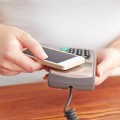 Woman paying with NFC technology on mobile phone