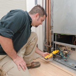HVAC technician using a meter to check heat pump amperage