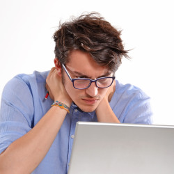 Hombre joven preocupado trabajando en un ordenador porttil.